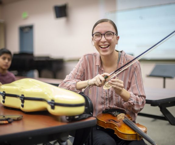 a happy music teacher with a violin